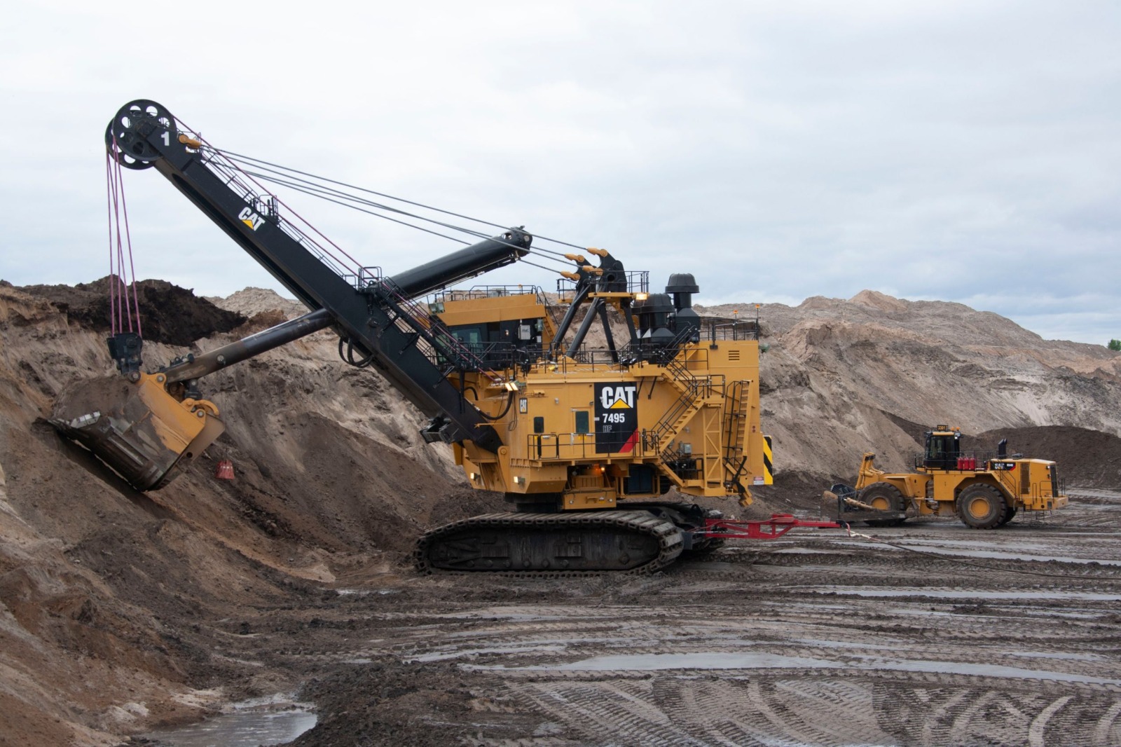 Pala de cable CAT 7495 con cargador frontal en faena minera a gran escala